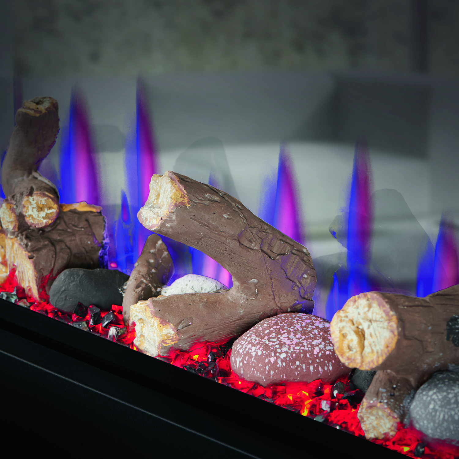 Decorative fireplace with glowing red and blue flames and assorted rocks and pebbles.