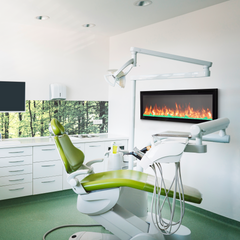 Modern dental office with green dental chair and white cabinets.