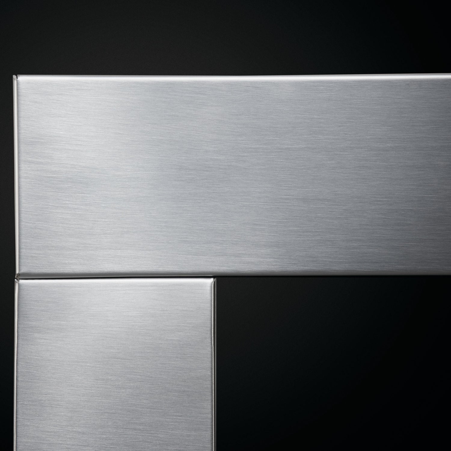 Close-up of a metallic surface with a reflective finish on a black background