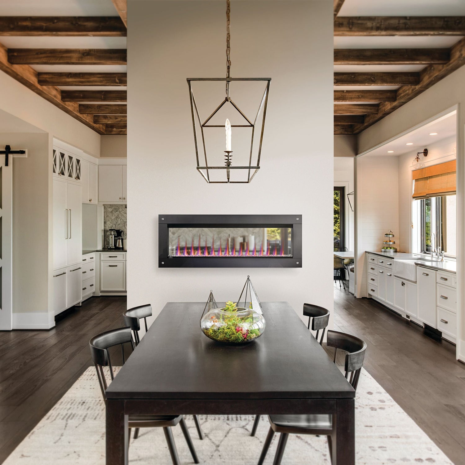 Modern dining room with a fireplace and wooden ceiling beams.