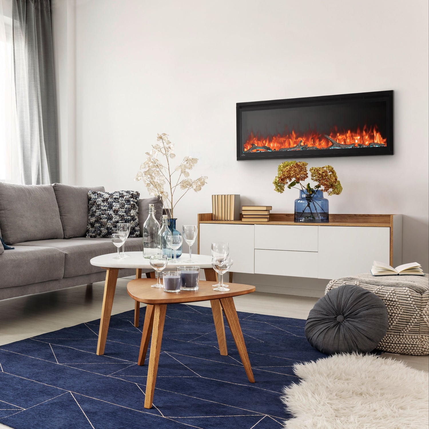 Modern living room with gray sofa, coffee table, and TV displaying a fireplace.